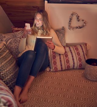 She speaks tech fluently. a young woman texting on her smartphone while relaxing in her bedroom at home.