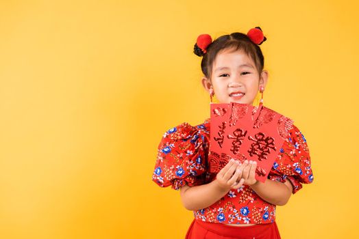 Happy Asian Chinese little girl smile wear red cheongsam qipao hold angpao red packet monetary gift