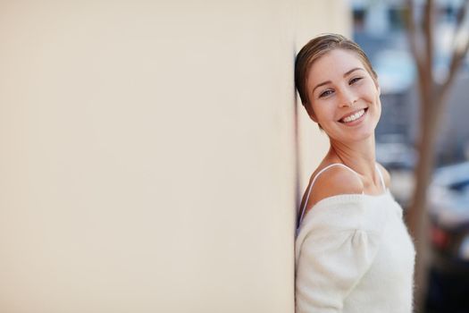 Happiness looks gorgeous on you. Portrait of a smiling young woman standing outside.