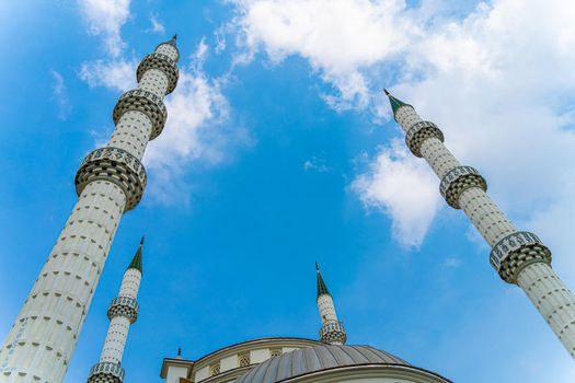 White mosque minaret. Mosque minaret with clouds in the background in Turkey