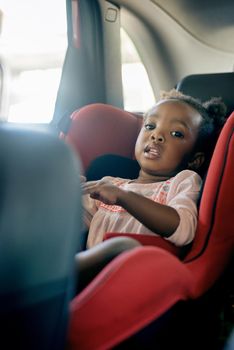 I always wear my seatbelt. Cropped portrait of an adorable little girl sitting in a carseat.