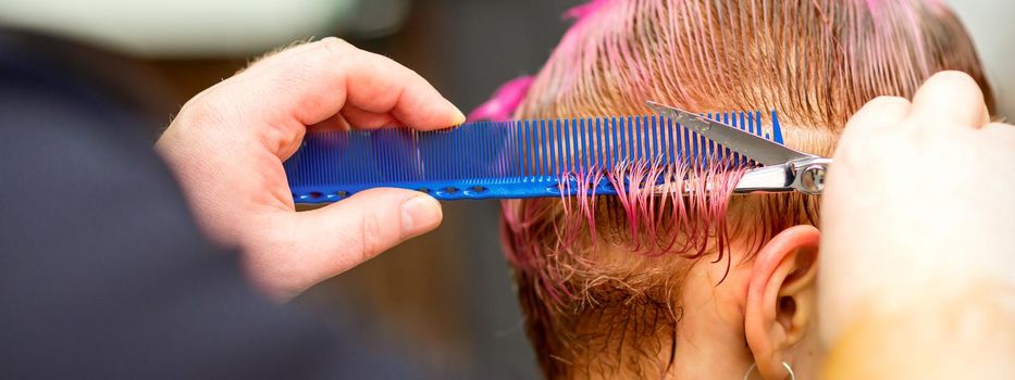 Woman with pink hair getting short haircut