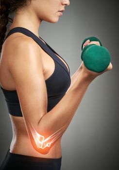 Ive been doing this for years now. Studio shot of an unrecognizable young woman holding a dumbbell while CGI shows an injury in her elbow.