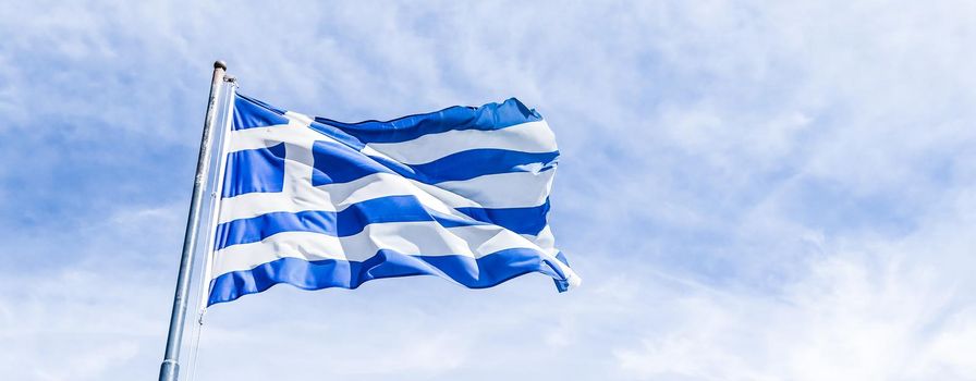 Greek flag and cloudy sky in summer day, politics of Europe