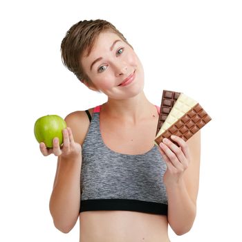 Eat less sugar, youre sweet enough as you are. Studio portrait of a fit young woman deciding whether to eat chocolate or an apple against a white background.