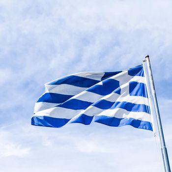 Greek flag and cloudy sky in summer day, politics of Europe