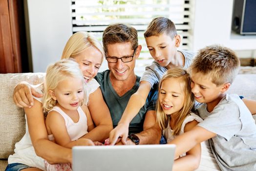 Theyve got curious young minds. a family using a laptop together at home.