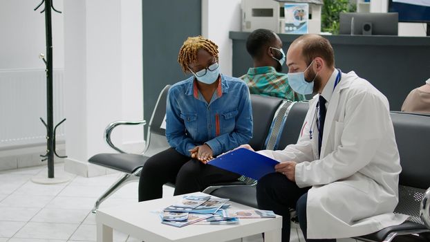 African american woman talking to physician at hospital reception