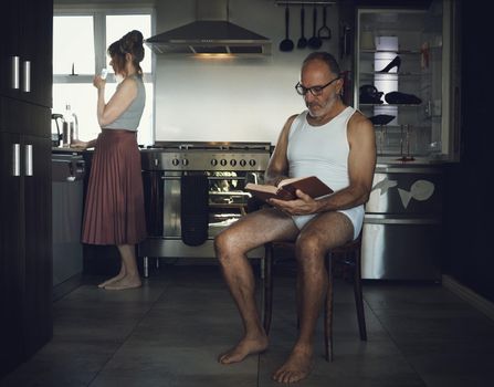 Marriage, problem and mental health issue with bored old couple in toxic, dark or sad family home kitchen together. Divorce, alcoholic and depression married relationship with broken household