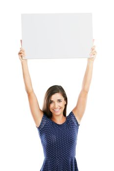 Can I get your attention please. Studio portrait of an attractive young woman holding up a blank placard against a white background.