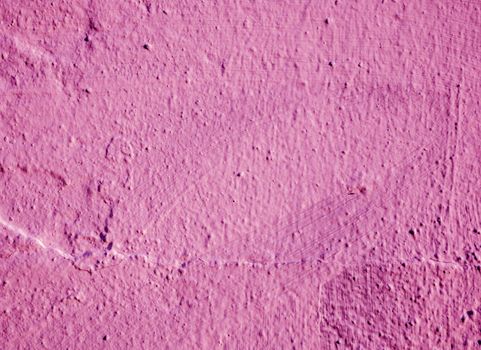 The surface of the old shabby magenta plaster on the wall.