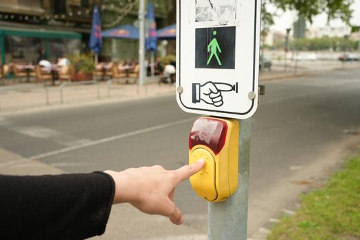 Hand changing the road sign to be able to cross