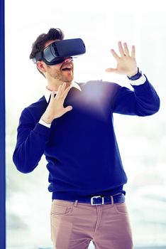On a trip through cyberspace. a businessman wearing a VR headset in an office.