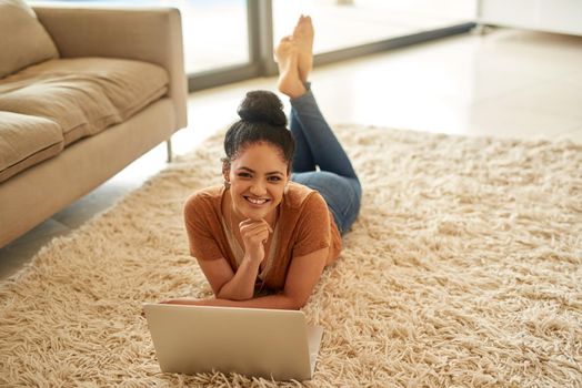 Chilling is the best when there is wifi involved. a beautiful young woman using a laptop at home.