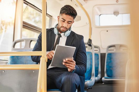 Business man, using tablet and bus for travel to work, home or working location. Relax businessman using headphones, public transport to cbd and mobile device to update social media or check schedule.