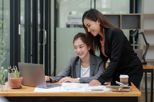 Two Asian Business woman working together by laptop at office