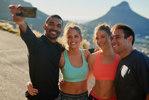 Its fun being involved in a group. a group of friends taking a selfie while out for a workout.