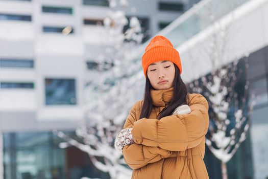 Beautiful asian woman waiting for a partner, dating after online dating, cold winter day with snow