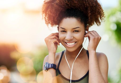 I turn up when the music is on. a young woman inserting her earphones before a run.