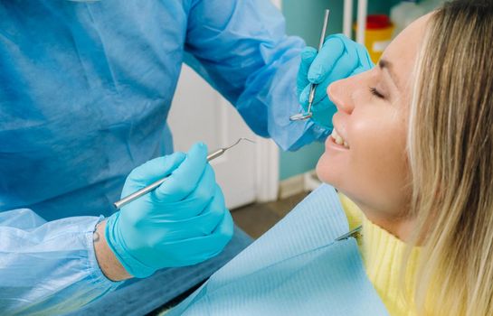The patient treats her teeth at the dentist in the dental office . Dental fillings