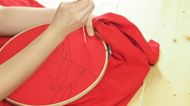 Woman hands and craft work. Embroider sewing by hand. 