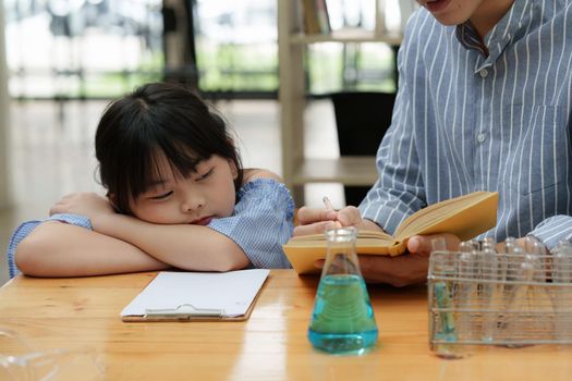 Kid sleeping while doing science experiments. Education science concept