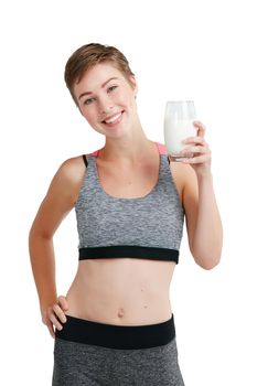 Milk does the body good. Studio portrait of a fit young woman holding a glass of milk against a white background.