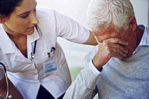 Caring for patients with compassion. a caregiver consoling a depresed senior man.