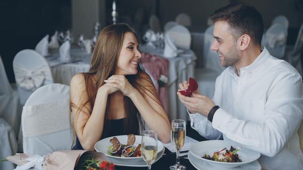 Attractive young woman is saying yes to marriage proposal. Romantic relationship and restaurant date concept