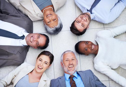 Its important to have good business relationships. High angle portrait of a group of diverse businesspeople lying on the floor in a circle.
