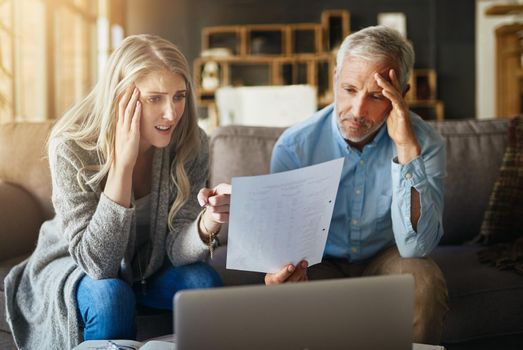 Did we really rack up so much debt. a couple looking anxious while doing their budget at home.