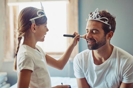 Theres nothing less manly about being a caring father. a little girl putting makeup on her father.