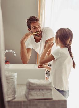 Keeping our pearly whites clean and bright. a happy father and his little girl washing their hands together in the bathroom.