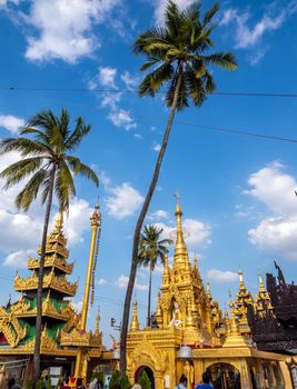 Group of golden pagoda and square hall mondop and golden tiered umbrella under the blue sky