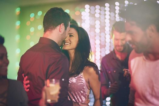 Get closer to me. an affectionate young couple dancing on a crowded dance floor in a nightclub.