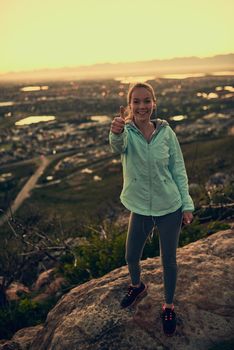 My progress is simply positive. Portrait of a sporty young woman giving you thumbs up during a hike up the mountain.