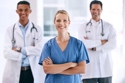 Portrait of medical doctors with crossed arms with a stethoscope standing in the hospital hallway. Happy healthcare workers after clinic trial, surgery or consultation success at a medicare center.