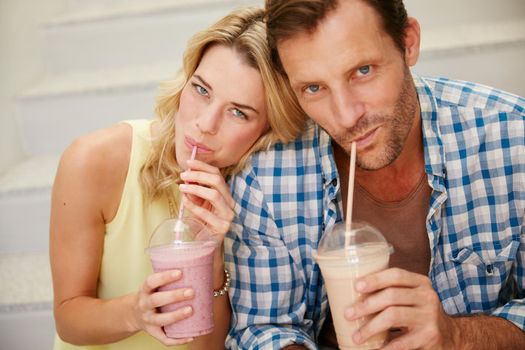 Chill out with something tasty. a happy couple enjoying refreshing shakes together.