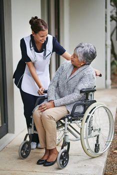 I appreciate your support. a senior woman in a wheelchair being for for by a nurse at a retirement home.