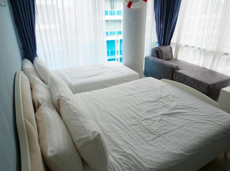 Large beds and wrinkled mattresses. In the bedroom, there is a glass wall on the high building