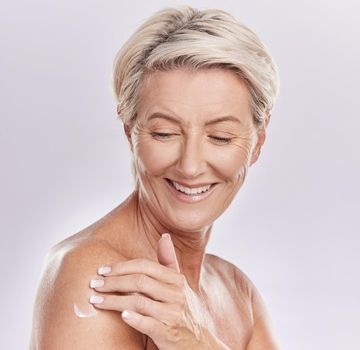Skincare cream, naked and senior woman mockup studio background. Self care, anti ageing and beauty wellness for healthy body. Mature lady happy with glowing skin pamper application routine.