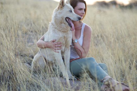Life is good with a faithful friend by your side. an attractive young woman bonding with her dog outdoors.