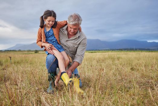 Happy family bonding on farm grandparent and girl having fun in nature, prepare for walk together. Smiling child and caring grandfather exploring outdoors, enjoying a walk in the countryside or field