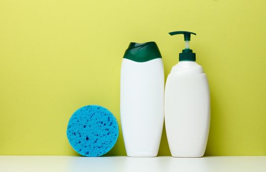 White plastic bottles with a pump for shampoo, shower gel 
