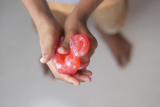child Hand holding pink color slime