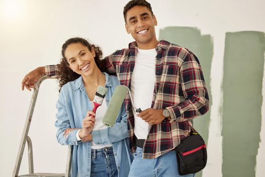 Painting, love and home with a couple doing DIY, renovation and house remodel with a paintbrush and roller. Domestic relationship and teamwork with a man and woman ready to paint a room