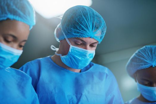 Mental precision and focus is crucial. a team of surgeons performing a medical procedure in an operating room.