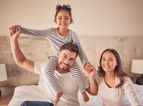 Family, mother and father with happy girl sitting in bedroom together spending quality time relaxing at home. Smile, parents and freedom with young child on dads shoulders next to mom in portrait
