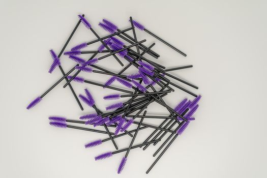 Purple makeup brushes, eyelash combs and eyebrows on white background with copy space