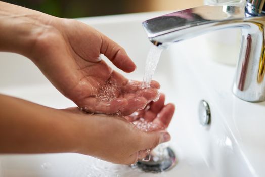 Staying clean and fresh. a hands being washed at a tap.